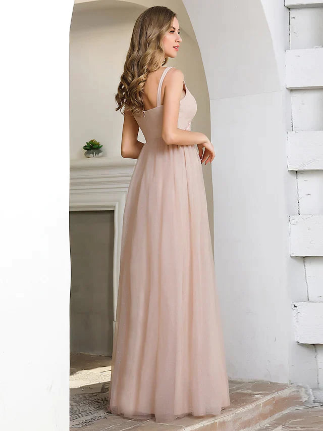 Side view of a woman in an A-line plunging neck tulle bridesmaid dress with appliques.