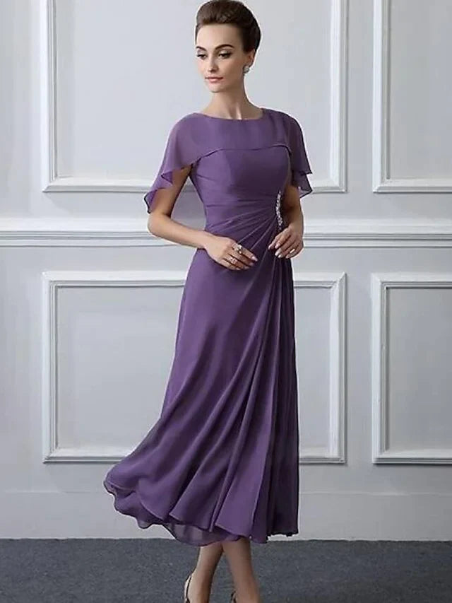 Close-up of the crystal brooch and delicate ruffles on the chiffon short sleeve dress.