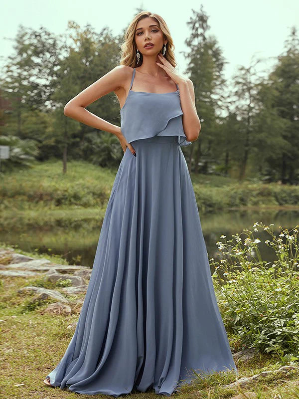 Woman wearing an A-line chiffon bridesmaid dress with spaghetti straps and ruffles.