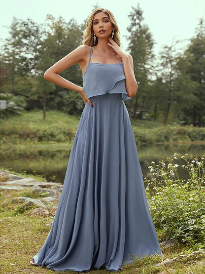 Woman wearing an A-line chiffon bridesmaid dress with spaghetti straps and ruffles.