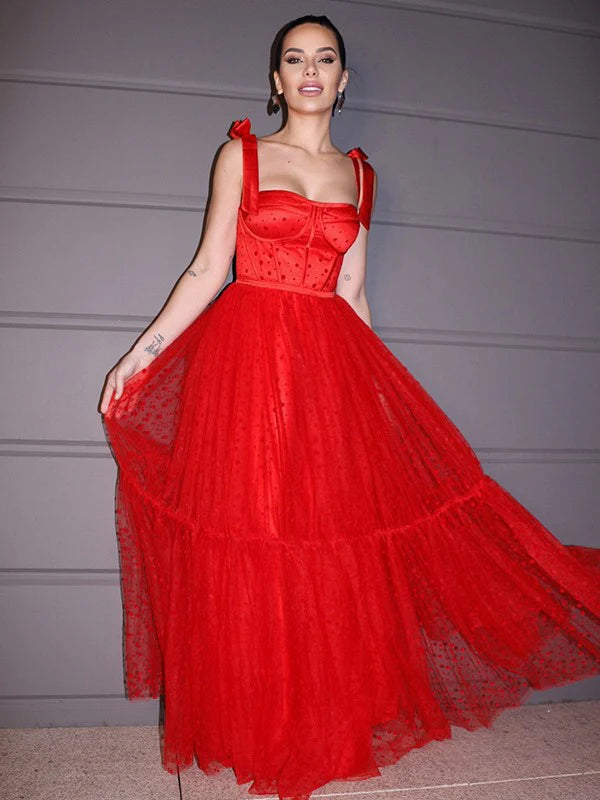 Front view of a woman wearing a red A-line princess prom dress with lace and ruffles.