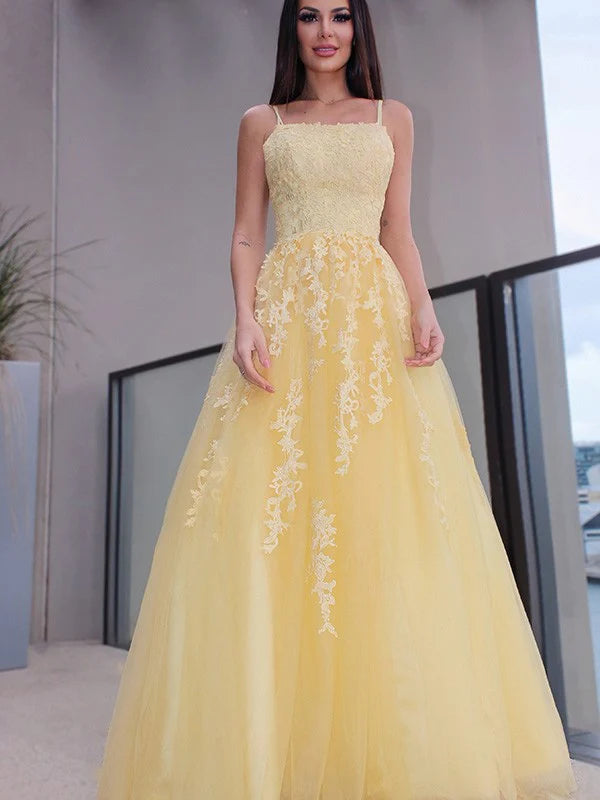 Model wearing an elegant A-line princess prom dress with spaghetti straps and applique details.