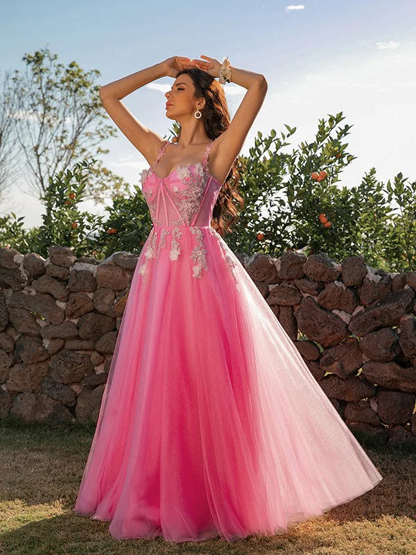 Woman wearing an elegant A-line princess tulle applique floor-length prom dress.