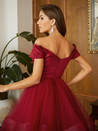 Model showcasing the flowing A-line princess skirt and off-shoulder design of the prom dress, side view.