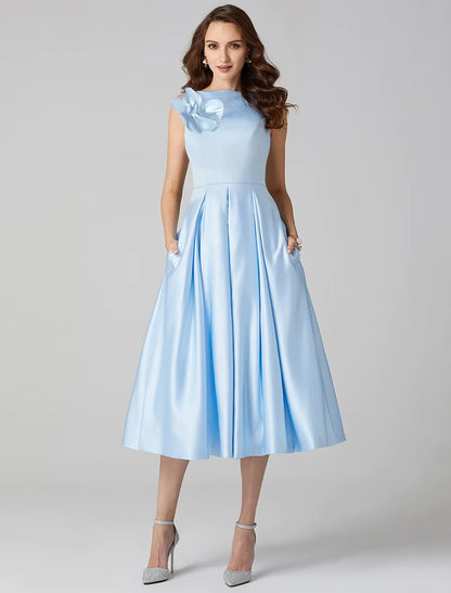 Elegant A-Line satin cocktail dress with jewel neck, tea length, pleats, and shoulder flower detail.