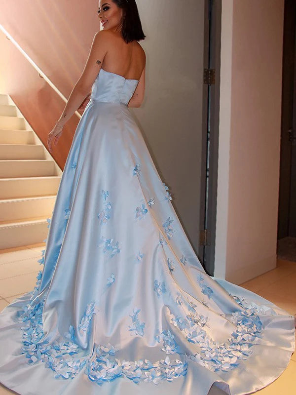 Back view of an A-Line satin strapless prom dress with hand-made flowers.