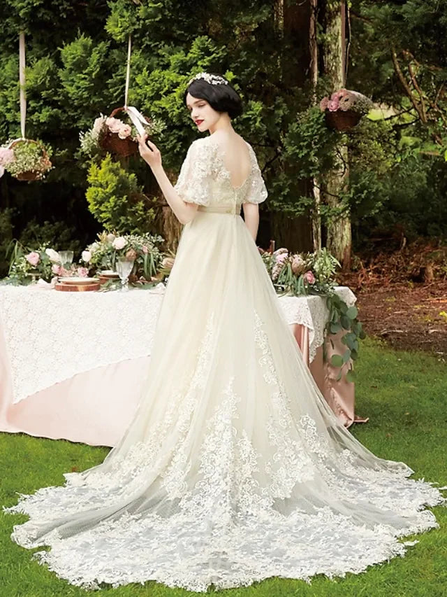 A-Line wedding dress with chapel train and lace details, side view.