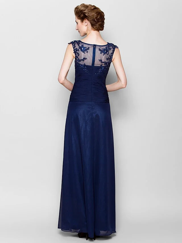 Side view of a woman wearing a flowing navy blue floor-length chiffon dress.
