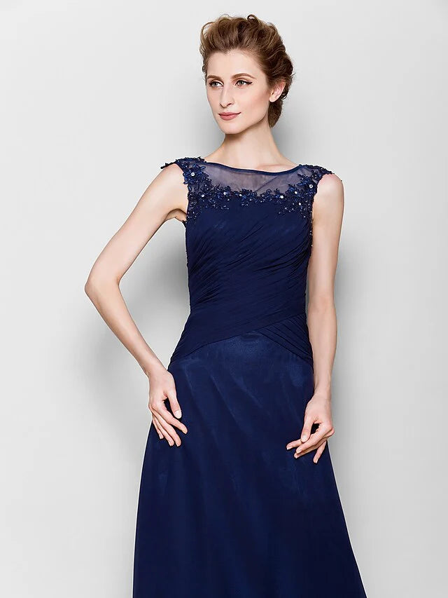 Close-up of the sheer scoop neck bodice with delicate appliques on the navy blue gown.