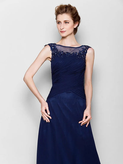 Close-up of the sheer scoop neck bodice with delicate appliques on the navy blue gown.