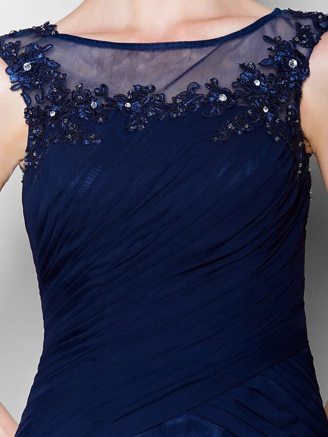Woman posing in a navy blue sleeveless chiffon Mother of the Bride dress.