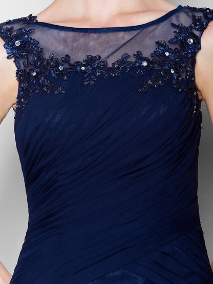 Woman posing in a navy blue sleeveless chiffon Mother of the Bride dress.