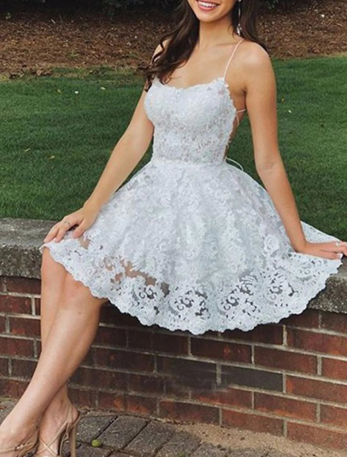 Model wearing an elegant A-line short floral homecoming dress with spaghetti straps and lace appliques.
