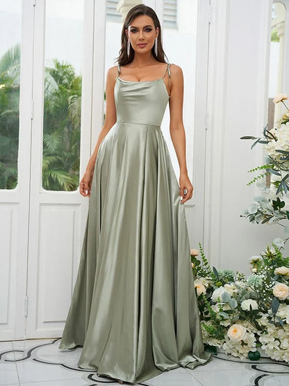 A woman in a light-colored A-line bridesmaid dress with ruffles and spaghetti straps, viewed from the side.