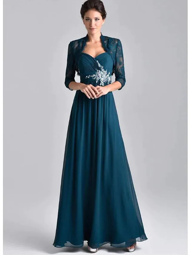 Model wearing an elegant two-piece A-line mother of the bride dress with spaghetti straps, 3/4 sleeves, lace, and embroidery.