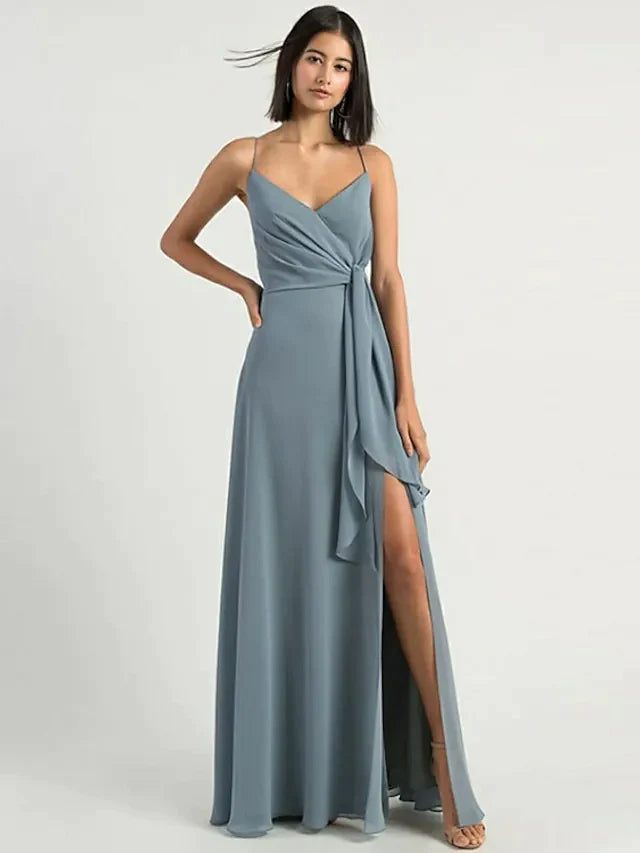 Woman wearing an elegant A-line chiffon bridesmaid dress with spaghetti straps and a split front.