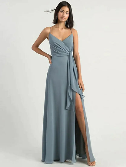 Woman wearing an elegant A-line chiffon bridesmaid dress with spaghetti straps and a split front.