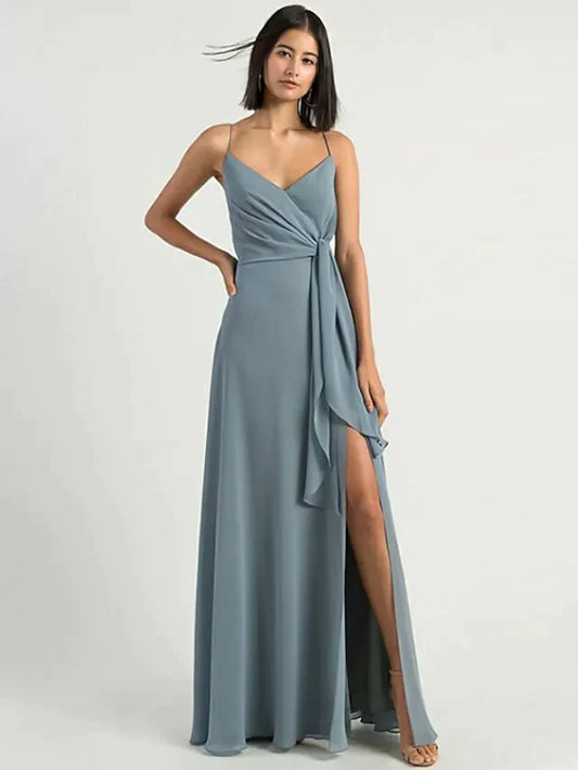 Woman wearing an elegant A-line chiffon bridesmaid dress with spaghetti straps and a split front.