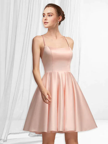 Woman wearing an A-line spaghetti strap mini satin dress with pleats, front view.