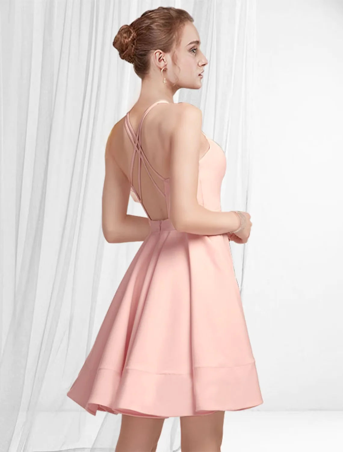 Woman posing in a chic pleated satin cocktail dress.