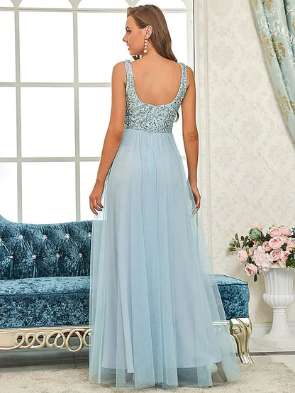 Side view of a woman in a sparkling A-line sequined gown, showcasing the flowing tulle skirt.