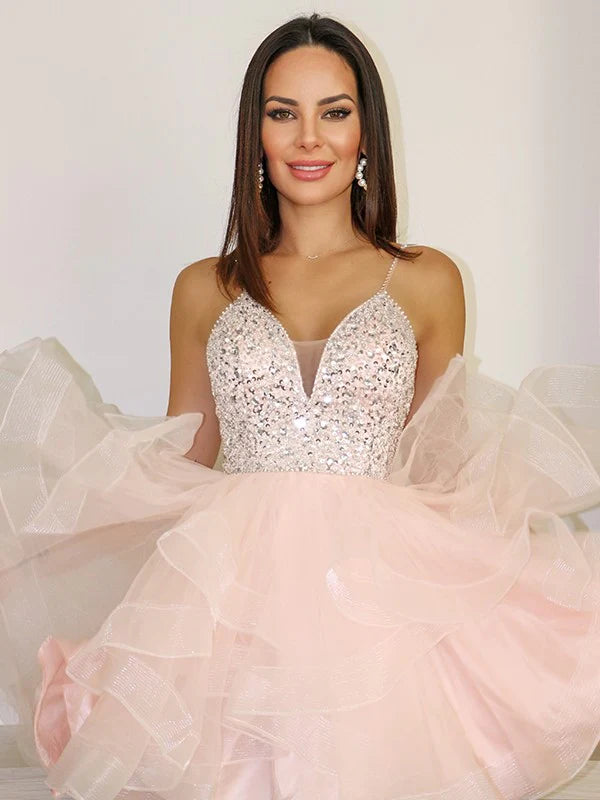 Front view of a woman wearing an elegant spaghetti straps lace applique mini homecoming dress.