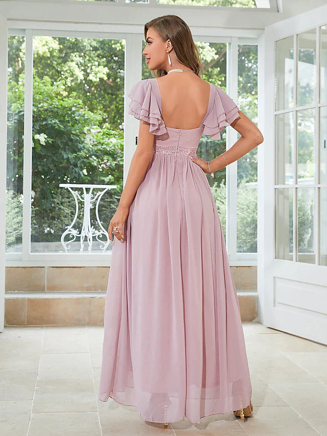 Side view of a woman wearing a light blue A-line floor-length dress with square neckline and ruffles.