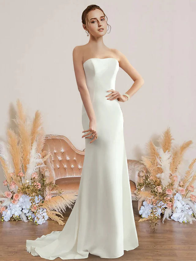 Woman wearing an elegant white strapless chiffon wedding dress.