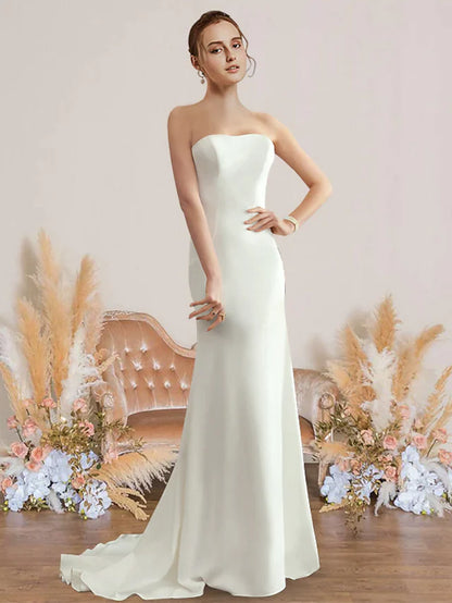 Woman wearing an elegant white strapless chiffon wedding dress.