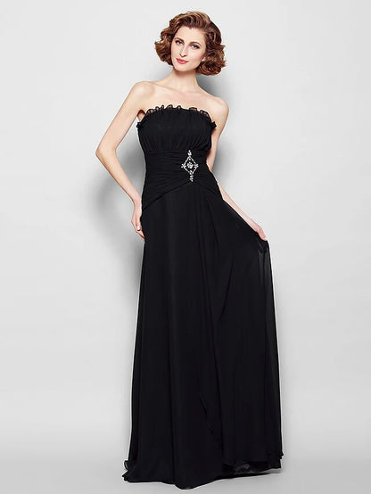 Woman in elegant A-line strapless chiffon Mother of the Bride dress with ruched bodice, beading, and ruffles.
