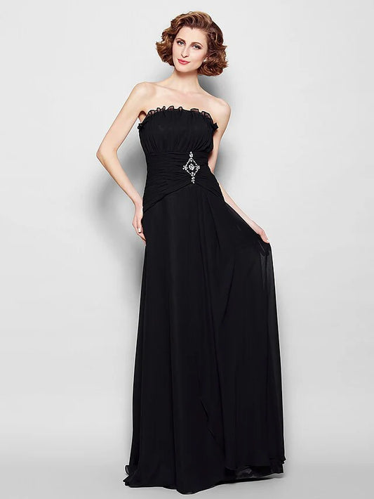 Woman in elegant A-line strapless chiffon Mother of the Bride dress with ruched bodice, beading, and ruffles.