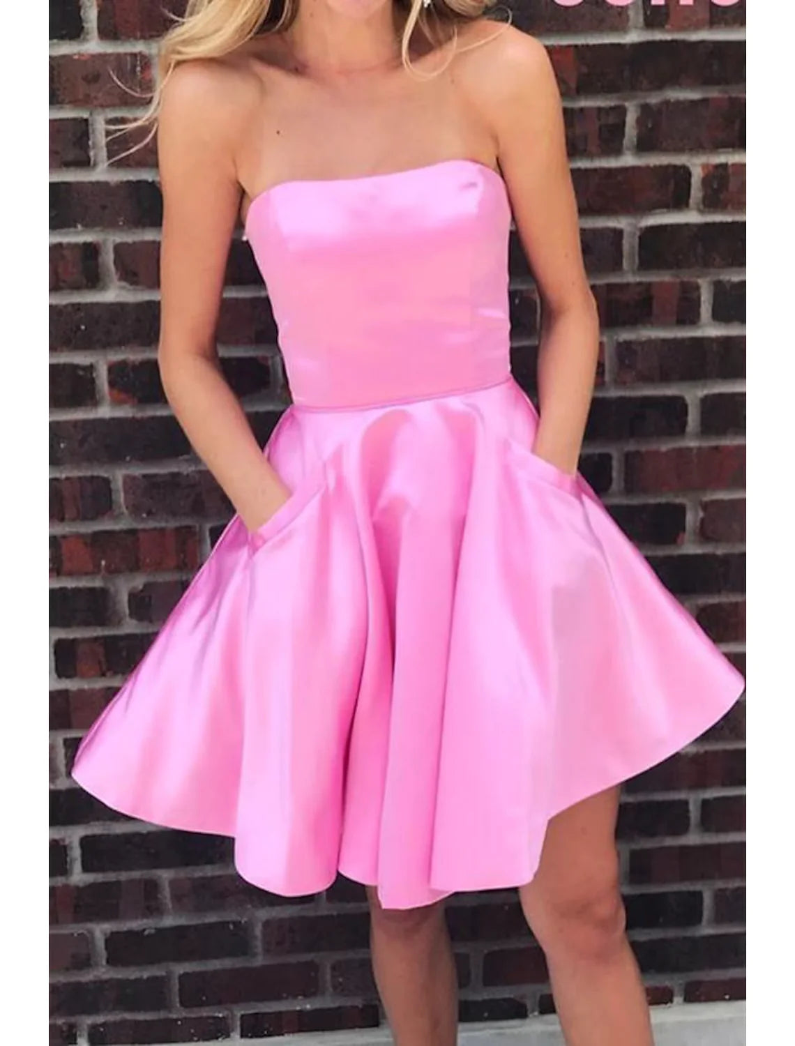 Close-up of the pleated skirt on a short satin party dress.