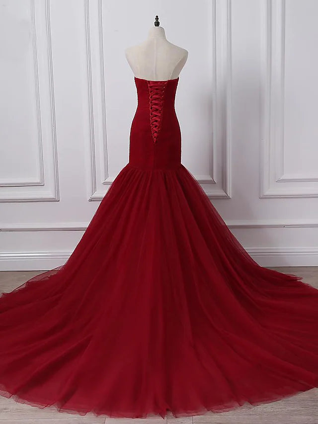 Back view of a plus size A-line strapless wedding dress showing the chapel train and ruched details.