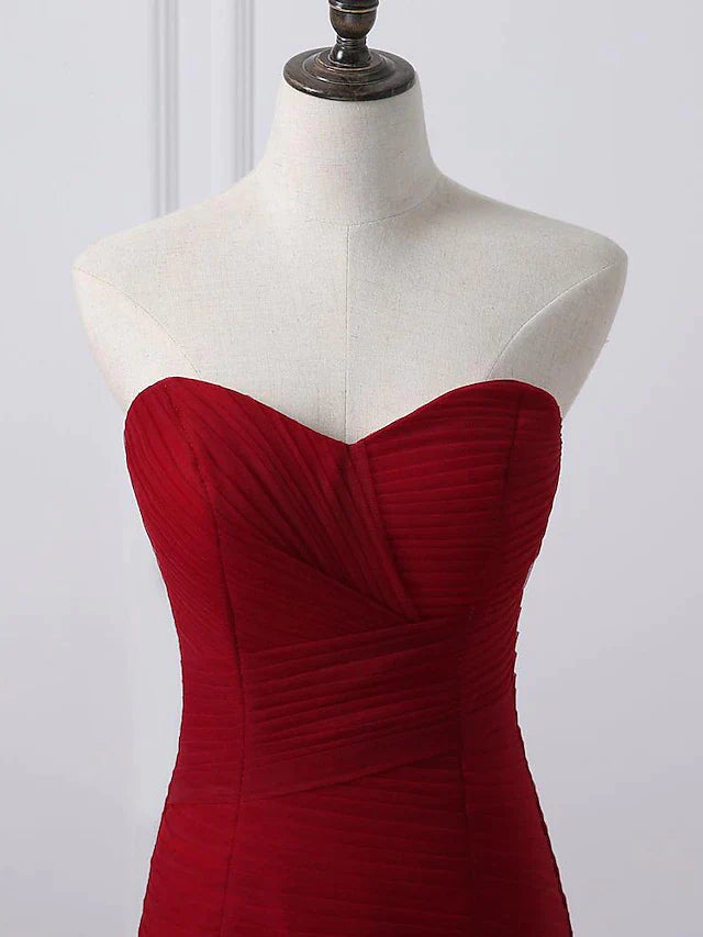 Close-up of the ruched bodice and flowing tulle skirt of a plus size strapless wedding gown.
