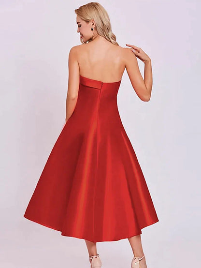 Side view of a model in a strapless satin A-line tea-length dress.