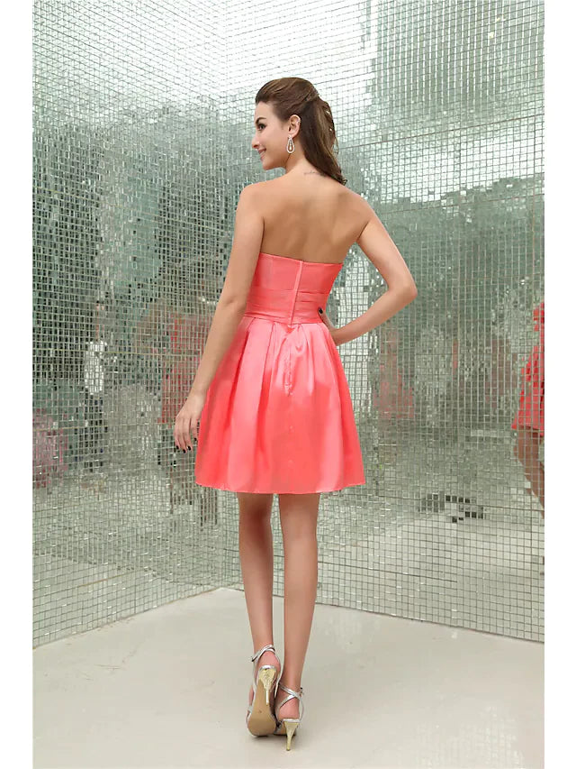 Back view of an A-line strapless short mini taffeta cocktail dress with intricate pleating and beading.