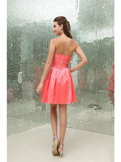 Back view of an A-line strapless short mini taffeta cocktail dress with intricate pleating and beading.