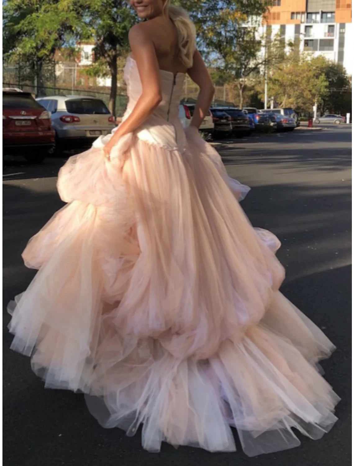 Side view of the A-line strapless evening gown, highlighting the flowing tulle skirt and ruched bodice.