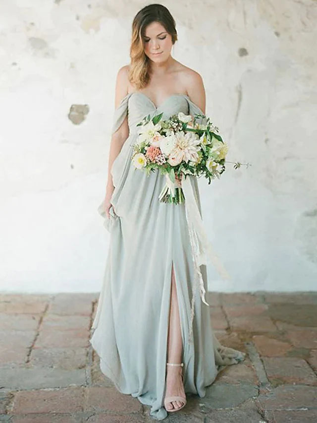 Woman wearing an elegant A-line sweetheart chiffon bridesmaid dress with pleats and a split front.