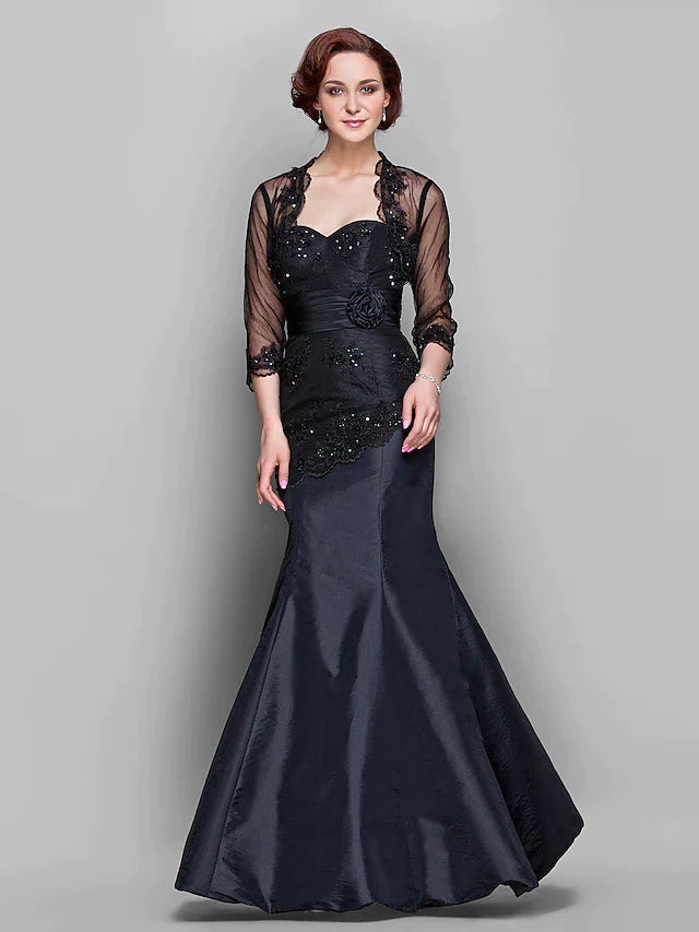 Woman wearing an elegant floor-length Mother of the Bride dress with a sweetheart neckline, long sleeves, and lace.