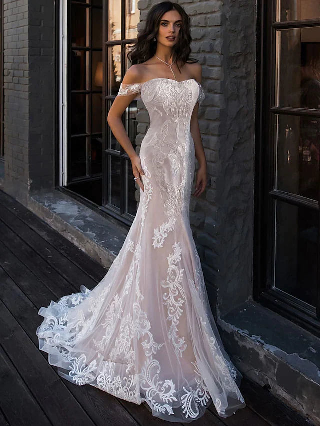 Bride wearing an A-Line boho lace wedding dress with sweetheart neckline and court train.