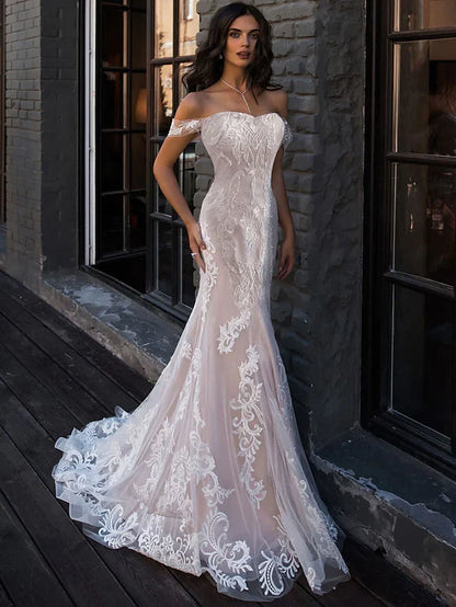 Bride wearing an A-Line boho lace wedding dress with sweetheart neckline and court train.