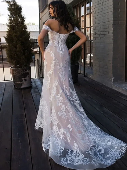 Back view of an A-Line lace wedding dress, showing illusion detail and court train.