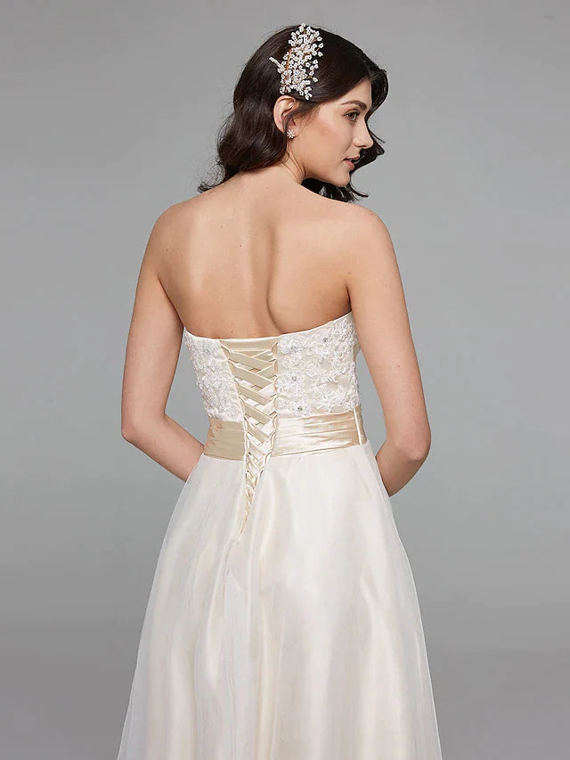 Side profile of the bride in a strapless A-line gown, showcasing the asymmetrical lace design.