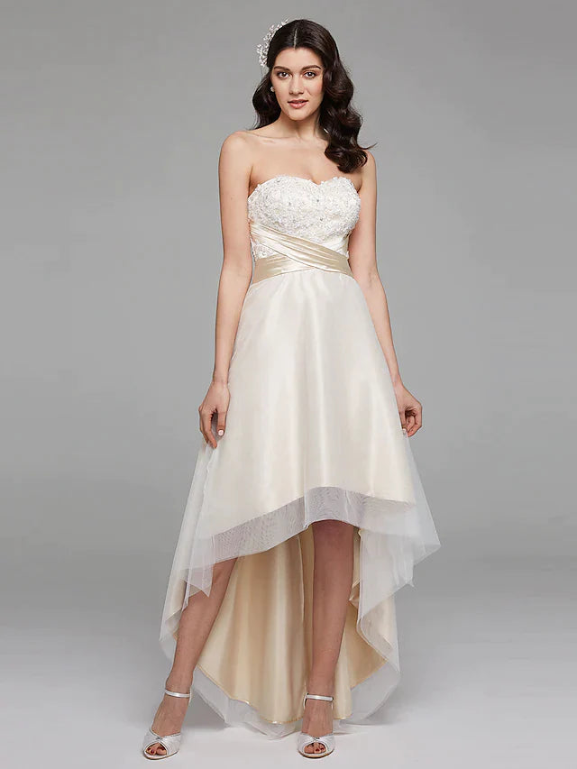 Detailed view of the delicate bowknot sash with ribbon beading on the satin wedding dress.