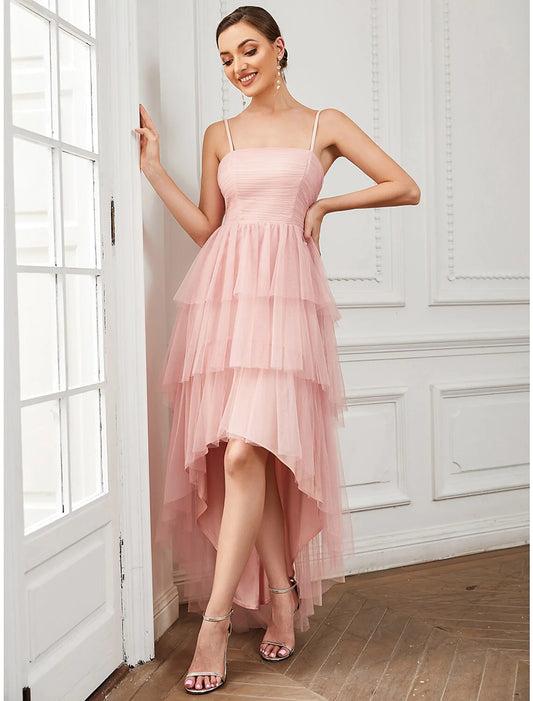 Woman wearing an elegant A-line tulle ruched spaghetti strap knee-length vintage prom dress.