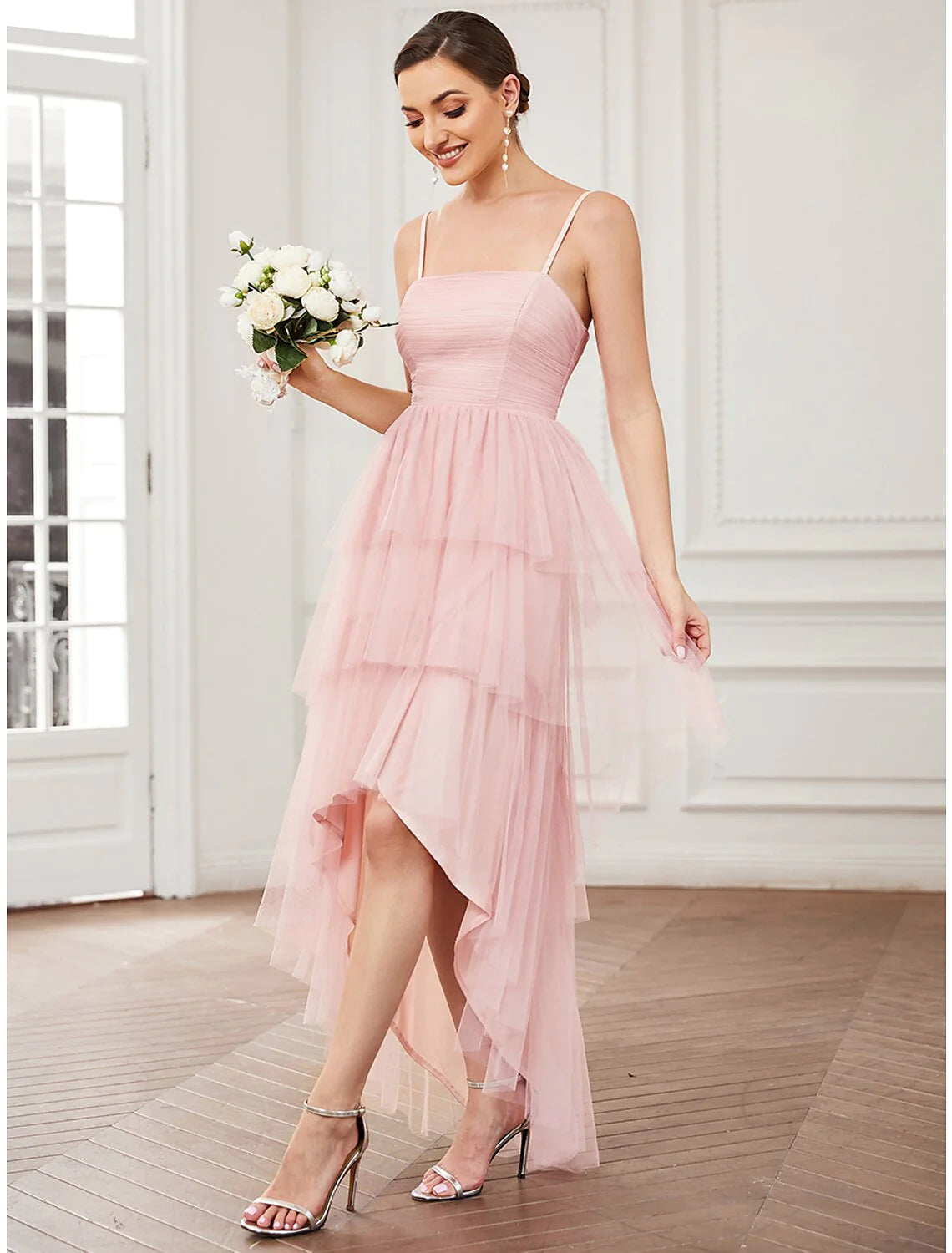 Woman posing in a sleeveless A-line tulle dress, suitable for prom or parties.