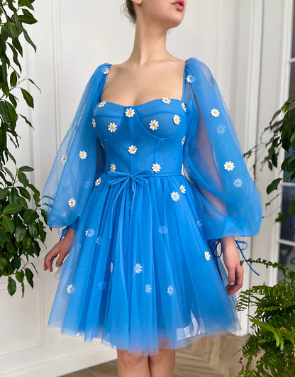 Detailed close-up of the delicate blue tulle fabric on the short party dress.