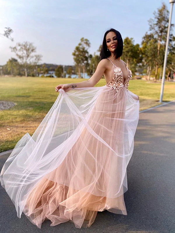 Model wearing an elegant A-line tulle V-neck sleeveless prom dress with hand-made flower details, front view.