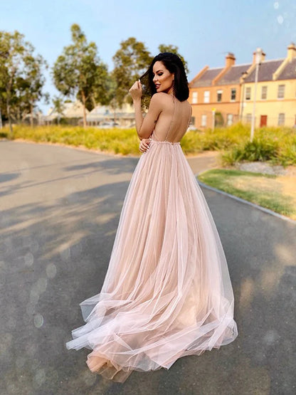 Side view of a model in the A-line tulle V-neck sleeveless prom dress, showcasing the flowing skirt.
